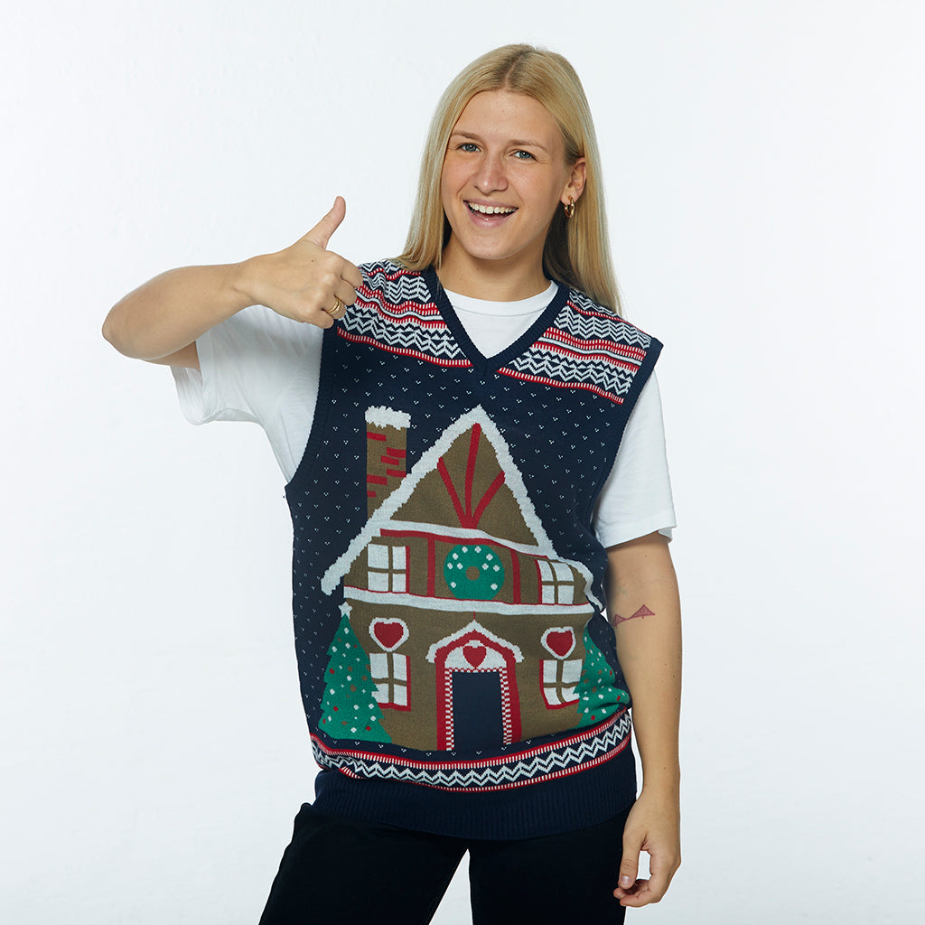 En dame vender tomlen op og smiler, mens hun har en julevest på.